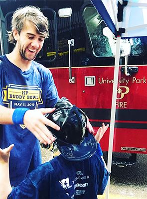 Firefighter Putting Fire Helmet on Kid